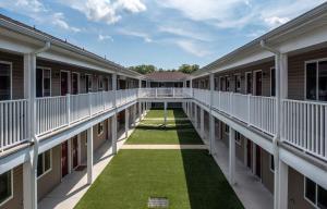 斯塔福德Affordable Suites of America Stafford Quantico的一座绿草如茵的学校建筑的空旷庭院