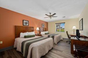 斯塔福德Affordable Suites of America Stafford Quantico的酒店客房配有两张床和吊扇。