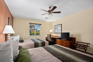 斯塔福德Affordable Suites of America Stafford Quantico的酒店客房配有两张床和吊扇。