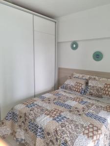 萨尔瓦多1/4 na praia de Armação的一间卧室配有两张床,床上有被子