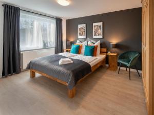 弗伦斯堡Ferienwohnung Flensburg的一间卧室配有一张带蓝色枕头的床和一扇窗户。