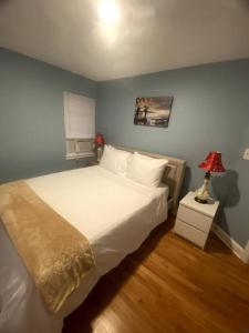 波士顿Cozy Boston Getaway Apartment的卧室配有白色的床和蓝色的墙壁