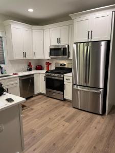 彭萨科拉The Clifford House的厨房配有白色橱柜和不锈钢冰箱