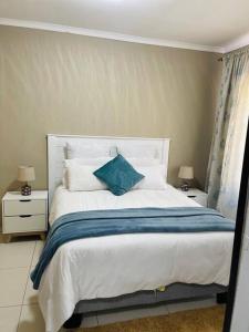 哈博罗内Central Gabs Oasis: 2BR-Retreat的一间卧室配有一张带蓝色枕头的床