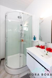波拉波拉Matira Beach Raitea 2的一间带玻璃淋浴和水槽的浴室