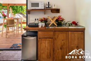 波拉波拉Matira Beach Raitea 2的厨房配有水槽和带微波炉的台面。