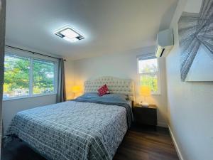 西雅图Modern Home with Air Conditioners Near Bitter Lake的一间卧室设有一张床和两个窗户。