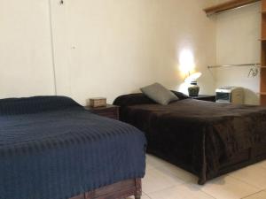 瓦哈卡市Trotamundo Oaxaca Hostel的一间卧室配有两张床和打印机