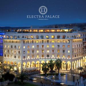 塞萨洛尼基塞萨洛尼基伊莱克特拉酒店的一座白色的大建筑,晚上有灯光