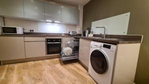 卡迪夫Modern One Bedroom Apartment in Cardiff Bay的厨房配有洗衣机和微波炉。