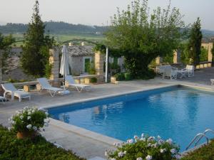 洛雷特-德维斯塔莱格罗塔帕勒姆农庄酒店的一个带椅子的游泳池以及一座房子