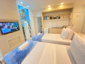 累西腓FLAT Praia Boa Viagem的酒店客房设有两张床和一台平面电视。