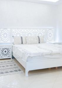 依索安Malak House的一间白色卧室,房间内设有白色的床