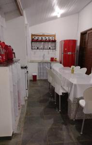 卡拉瓜塔图巴Cantinho do Sossego的餐厅设有白色桌子和红色冰箱