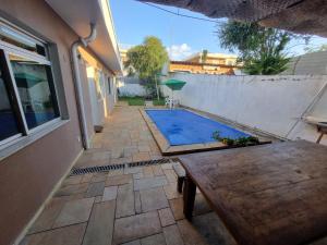 坎皮纳斯Quarto Bem Star na Lagoa do Taquaral的后院设有游泳池和木桌