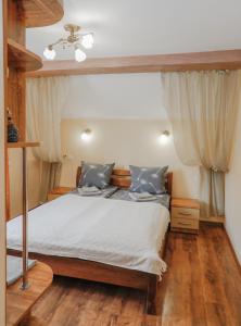 亚列姆切Фенікс的一间卧室配有一张铺有木地板的床和天花板