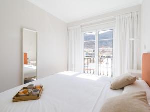 莫甘海滩Amarre Shell的白色的卧室设有白色的床和大窗户
