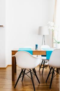 维也纳Home Sweet Apartments | contactless check-in的一间用餐室,配有两把白色椅子和一张桌子