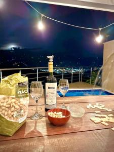 佛罗里达布兰卡Ruitoque Apartamento Campestre Maravillosa Vista的桌子上放有一瓶葡萄酒和两杯酒