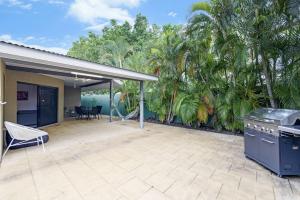 ParapAh Mat Bungalow - Tropical Darwin Stay with Pool的一个带烧烤和棕榈树的户外庭院