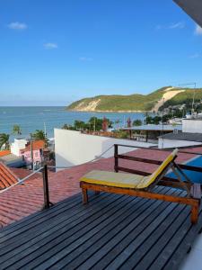 纳塔尔Encanto da Praia hotel pousada的屋顶上的长凳,享有海景
