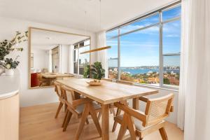 悉尼Harbour Bliss - Exquisite Design, Breathtaking Views的一间带桌子和大窗户的用餐室
