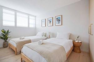 悉尼Harbour Bliss - Exquisite Design, Breathtaking Views的一间白色卧室,配有两张床和窗户