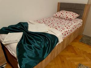 Kosovo PoljeMadigan's Hotel的一张床上有绿毯的床