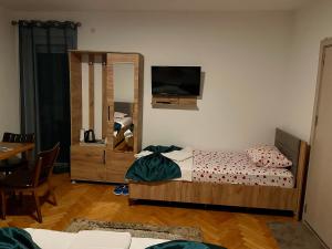 Kosovo PoljeMadigan's Hotel的卧室配有一张床,墙上配有电视。