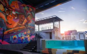 米里Mercure Miri City Centre的一座游泳池,在建筑物的一侧画着画