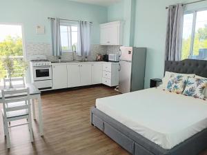 昂斯拉雷区Serenity Seaview Suite的一间卧室配有一张床和一间厨房