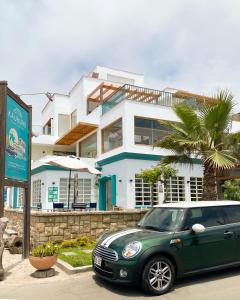 圣巴托洛Kauhuhu Casa Hotel的停在房子前面的绿色汽车