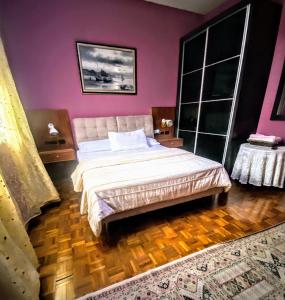 新山Guesthouse Khatib的一间卧室设有一张紫色墙壁的大床