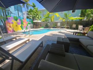 基韦斯特Duval Street Suite with pool的一个带桌椅和遮阳伞的游泳池