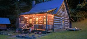 Rural RetreatThe Little Cabin on Huckleberry的小屋设有门廊和灯