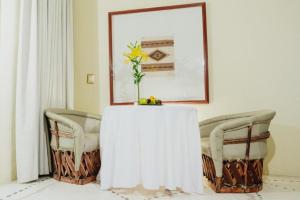 圣克鲁斯华特库华土尔科金塔实酒店的一张桌子,上面有花瓶,有两把椅子