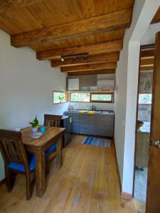 里奥内格罗cabaña paniym的厨房设有木桌和木制天花板。