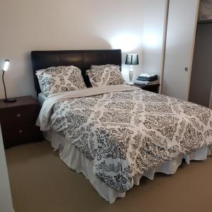 渥太华Lovely Guest Entire Apartment的一间卧室配有一张带黑白色棉被的床