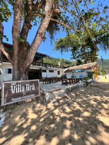 阿拉夏奇巴海滩Espaço Villa Ará的一座有树的建筑前面的标志