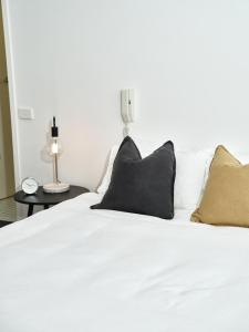 墨尔本Chic Urban Loft in Prime Location的一张带两个黑色枕头的白色床