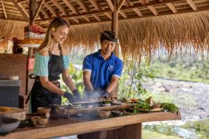 SilebengNatya River Sidemen的烤架上做饭的男人和女人