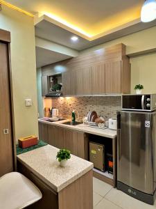 宿务Horizons 101 Condo in Cebu City的厨房配有木制橱柜和不锈钢冰箱。