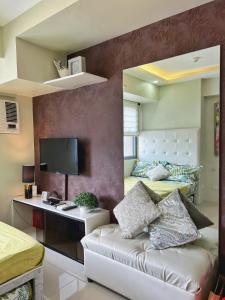 宿务Horizons 101 Condo in Cebu City的一间卧室配有两张床和一张带显示器的书桌。