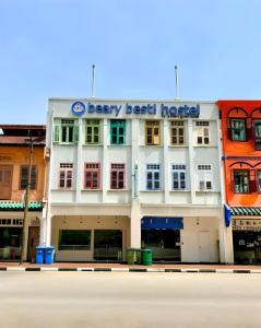 新加坡Beary Best! Hostel Chinatown的白色的建筑,前面有标志