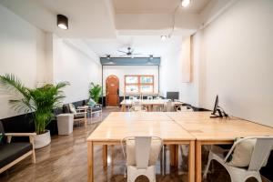 清迈Socialer Coliving & Coworking Space的一个带大木桌和椅子的办公室