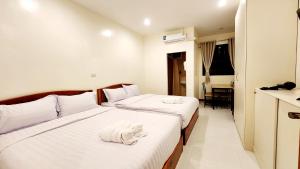 清刊Chotika Hotel โรงแรมโชติกา ณ เชียงคาน的酒店客房,配有两张带毛巾的床
