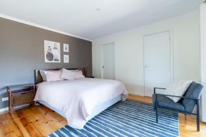 日落大道Sunset Meadows的卧室配有白色的床和蓝色地毯。