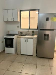 科马亚瓜Apartamentos Trebol的厨房配有白色橱柜和冰箱。