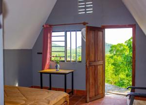 贡布Sabay Farm的一间卧室配有一张床、一张桌子和一个窗户。