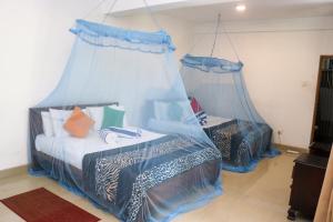 康提比姆度假村的一间卧室配有两张蓝色窗帘的床